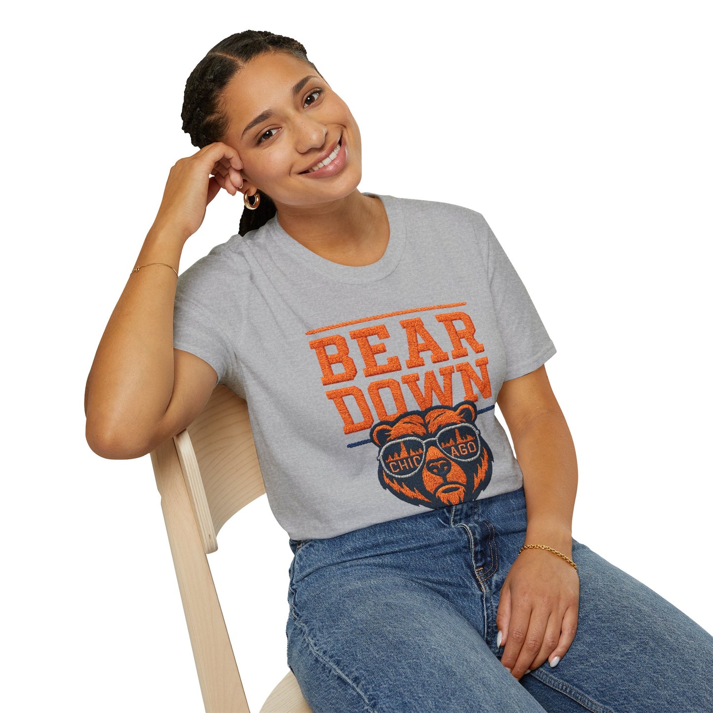 Woman wearing a gray t-shirt with 'Bear Down' and a bear graphic, sitting on a chair.